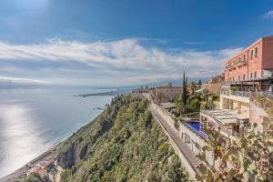 a town on a cliff next to the ocean at Domus Elisae - Taormina in Taormina