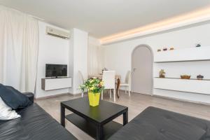 a living room with a couch and a table with flowers at Domus Elisae - Taormina in Taormina