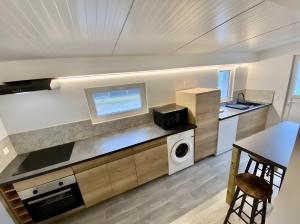 a kitchen with a washer and dryer and a table at La Cour de la Forêt in Saint-Mars-de-Coutais