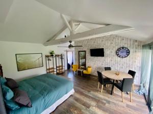 a bedroom with a bed and a table and chairs at La Cour de la Forêt in Saint-Mars-de-Coutais