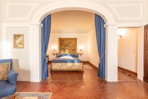 a bedroom with a bed with blue drapes at Residenza d'epoca Alcova in Lucignano +20 photos