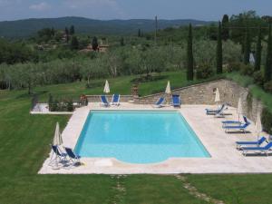a swimming pool with chairs and umbrellas at Residenza d'epoca Alcova in Lucignano
