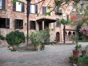 a building with a green hose in front of it at Residenza d'epoca Alcova in Lucignano