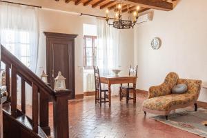 a living room with a table and a chair at Residenza d'epoca Alcova in Lucignano