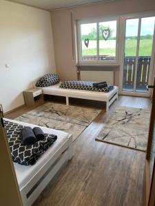 two beds in a room with two windows at Apartment Wohner in Petersaurach