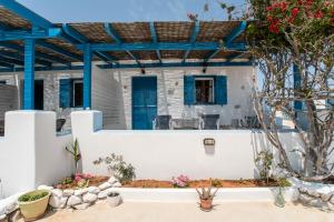 a house with white walls and blue windows at Mesaria Home in Donoussa +17 photos