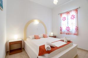 a white bedroom with a bed with towels on it at Mesaria Home in Donoussa