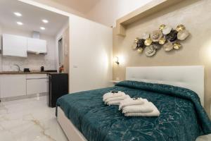 a bedroom with a bed with towels on it at Eralight21 Apartments in Bari +43 photos