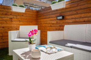 a patio with two chairs and a table with a flower at Max Apartment in Quartu SantʼElena