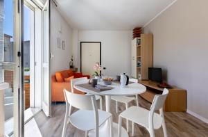 a dining room and living room with a white table and chairs at Max Apartment in Quartu SantʼElena