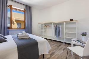 a bedroom with a white bed and a window at Max Apartment in Quartu SantʼElena