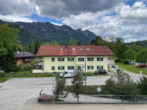 a large white building with cars parked in a parking lot at Ferienwohnung Inzell mit Bergblick in Inzell