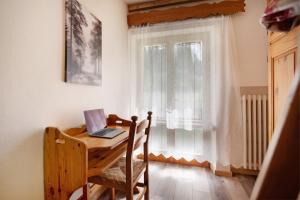 a wooden table with a laptop on it in front of a window at Casa de Lorenzo in Vodo Cadore