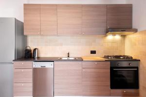 a kitchen with wooden cabinets and a sink at Casa de Lorenzo in Vodo Cadore