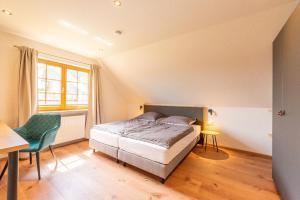 a bedroom with a bed and a table and a chair at Ferienwohnung Wälderliebe in Lenzkirch