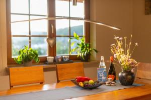 a table with a bowl of fruit and a bottle of wine at Ferienwohnung Wälderliebe in Lenzkirch +26 photos