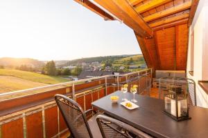 a balcony with a table with wine glasses on it at Ferienwohnung Wälderliebe in Lenzkirch