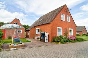 a red brick house with a playground in the yard at Huus Karoline in Junkersrott