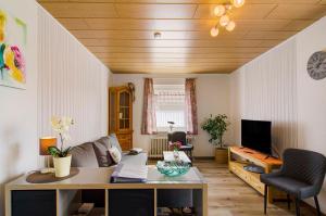a living room with a table and a tv at Huus Karoline in Junkersrott
