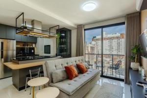 a living room with a couch and a kitchen at Soul República - Cidade Baixa in Porto Alegre