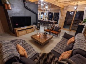 a living room with two couches and a tv at Chalet Friwi in Saint-Jean-de-Sixt