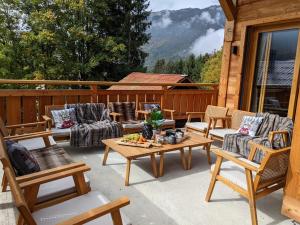 a patio with couches and a table and chairs at Chalet Friwi in Saint-Jean-de-Sixt