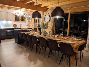 a large dining room table with chairs and a clock at Chalet Friwi in Saint-Jean-de-Sixt