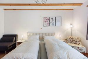 two beds in a room with a couch and a chair at Auszeit in Donaueschingen