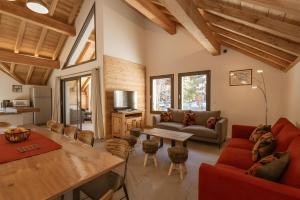 a living room with a red couch and a table at Chalet Le Strato in Valloire