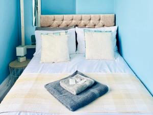 a bed with a blanket and a towel on it at Corvette in Trearddur
