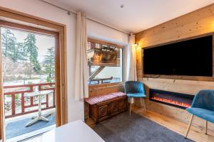 a room with a large tv and a window at La source in Brides-les-Bains