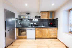 a kitchen with wooden cabinets and a stainless steel refrigerator at La source in Brides-les-Bains