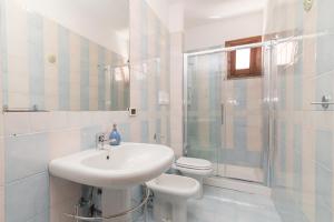 a white bathroom with a sink and a toilet at La Gioia in Palau +16 photos