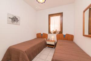 a bedroom with two beds and a window at La Gioia in Palau