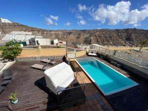 a swimming pool on top of a building with a mountain at Villa Happy Dreamer in Puerto Rico de Gran Canaria
