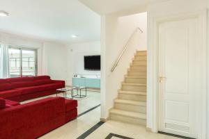 a living room with a red couch and stairs at Villa Happy Dreamer in Puerto Rico de Gran Canaria