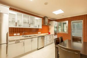a kitchen with white cabinets and a black counter top at Villa Happy Dreamer in Puerto Rico de Gran Canaria