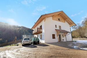 a house with a car parked in front of it at Töniglerhof Apt Abendrot in Trodena +10 photos