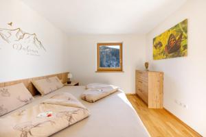 a bedroom with two beds and a dresser at Töniglerhof Apt Abendrot in Trodena
