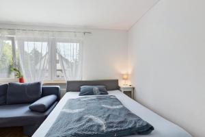 a bedroom with a bed and a couch at Ferienwohnung Pepe in Donaueschingen