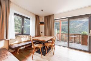 a dining room with a table and chairs and a balcony at Sonnleiten Sonnenadler 2 in Collepietra