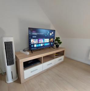 a flat screen tv sitting on top of a wooden entertainment center at Ferienwohnung Sena in Weisweil
