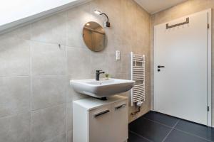 a bathroom with a sink and a mirror at Ferienwohnung Sena in Weisweil