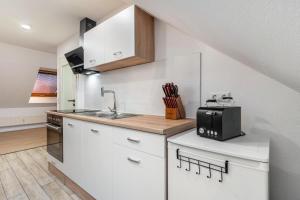 a kitchen with white cabinets and a sink at Ferienwohnung Sena in Weisweil