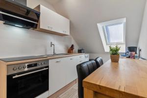 a kitchen with a table and a sink and a stove at Ferienwohnung Sena in Weisweil +14 photos
