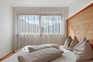a bedroom with a bed with pillows and a window at Pfösslerhof in Bolzano