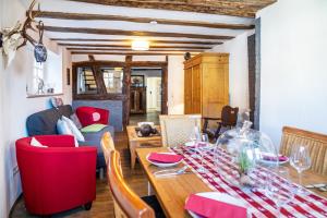 a dining room with a table and red chairs at Gästehaus Vis à Vis in Wallhausen