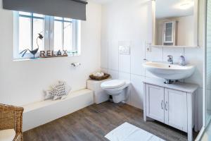 a white bathroom with a sink and a toilet at Gästehaus Vis à Vis in Wallhausen +23 photos