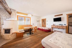 a bedroom with a room with a fireplace and a bed at La pratolina monolocale in Castello di Fiemme