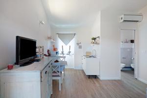 a white room with a desk with a television on it at Rosadimaggio Violetta in Arcola